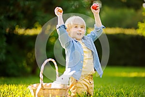 Charming little boy hunting for easter egg in spring park on Easter day