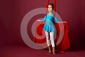 Charming little girl in a blue gymnastic suit