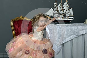 Charming little girl in elegant white with a pink dress sitting