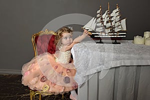 Charming little girl in elegant white with a pink dress sitting