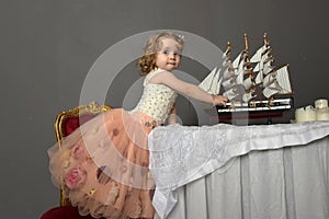 charming little girl in elegant white with a pink dress sitting