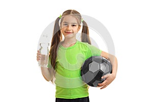 Charming little girl in green uniform with soccer ball