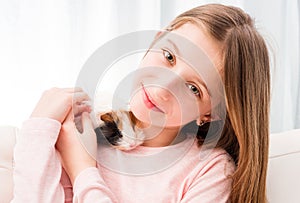 Charming little girl holding guinea pig