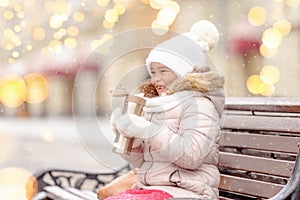 Charming little girl on swing in snowy winter