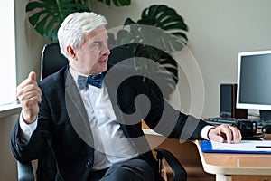 Charming mature gray-haired man at his desk.