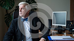 Charming mature gray-haired man at his desk.