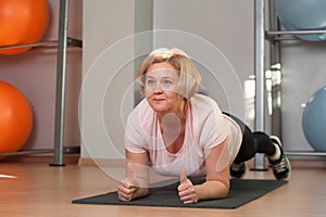 Charming Middle aged woman standing in plank position