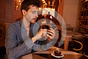 Charming millenial texting in a restaurant photo