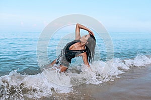 Charming miss in a stylish black swimsuit and bright makeup lies and relaxes on the beach.