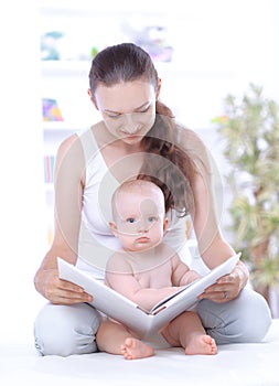 Charming mom reading a book to her baby