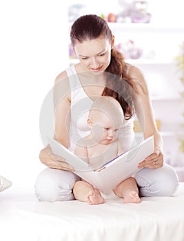 Charming mom reading a book to her baby