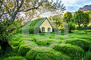 Charming mystical scene with turf roof church with windows and cemetery with small graves in Hof, Skaftafell, Vatnajokull National