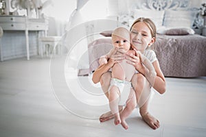 Charming pretty girl teenager holds baby