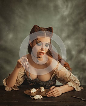 Charming redhead lady with cat ears made of hair eats white mice from golden dishes. Countess pussycat eats cute animals