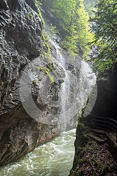 Charming scene of small waterfall with small river and fresh green trees in Aare gorge Aareschlucht