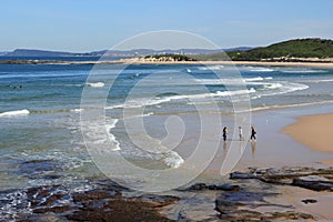 Charming seaside with three women strolling barefoot