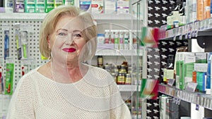 Charming senior woman smiling to the camera, shopping at drugstore