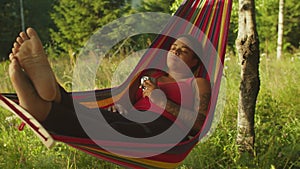 Charming serene black female hiker in hammock enjoying recreation and freedom in mountains