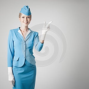 Encantador azafata en azul uniforme muestra dedo 