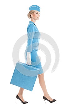 Charming Stewardess Dressed In Blue Uniform And Suitcase On White