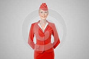 Charming Stewardess Dressed In Red Uniform On Gray Background.