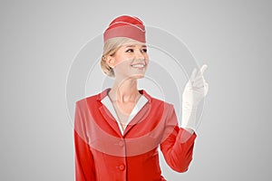Charming Stewardess Dressed In Red Uniform Pointing The Finger