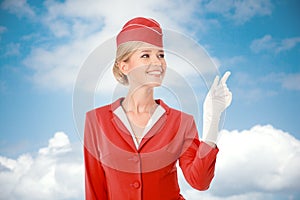 Charming Stewardess Dressed In Red Uniform Pointing The Finger.