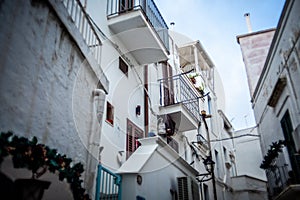 Charming Italian Balconies: White Buildings Adorned with Balconies in a Typical Polignano a Mare Street photo