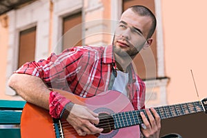 Charming street musician immersing in guitar practice