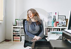 Charming tired adult woman middle aged with curly hair architect designer manager working in the bright modern office