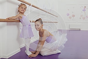 Charming two young ballerinas practicing at ballet class