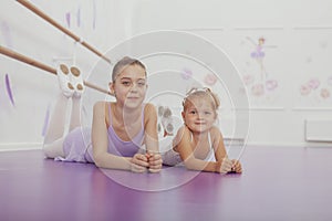 Charming two young ballerinas practicing at ballet class