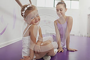 Charming two young ballerinas practicing at ballet class