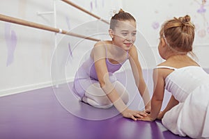 Charming two young ballerinas practicing at ballet class