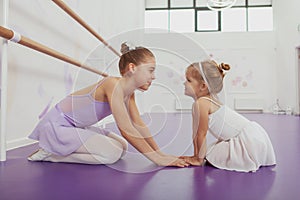 Charming two young ballerinas practicing at ballet class