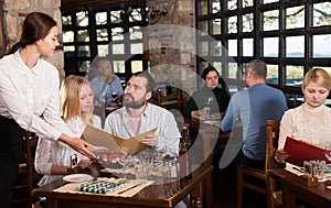 Charming  waiter receiving order from guests in country restaurant