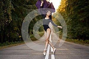 Charming Woman Ballet Dancer in Black Bodysuit is Fluttering Purple Fabric