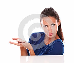 Charming woman in blue shirt holding palms up