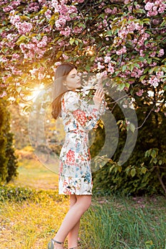 Charming woman in garden under flowering tree