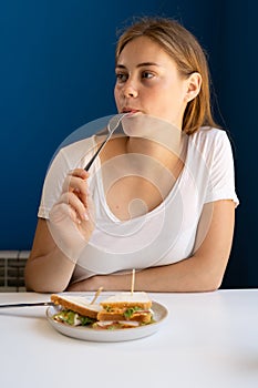 Charming woman having lunch during the rest in coffee shop, Caucasian female eating breakfast while relaxing in cafe