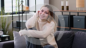 Charming Woman Laughing Sitting On Sofa At Home