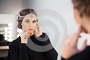 Charming woman looking at her reflection in the mirror