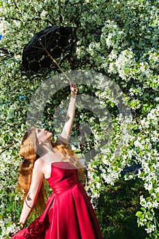 charming woman in red dress holding umbrella in hand