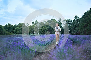 Charming woman running in lavender field.