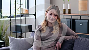 Charming Woman Sitting On Sofa At Home