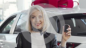 Charming woman smiling to the camera, holding car keys