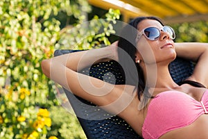 Charming woman sunbathing on the deckchair