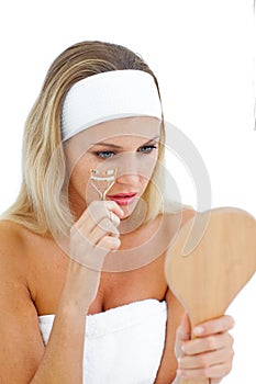 Charming woman using an eyelash curler