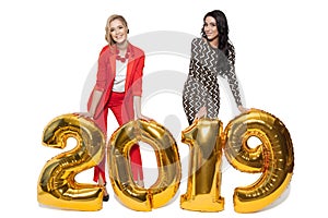 Charming Women Holding Big Golden Numbers 2019. Happy New Year.