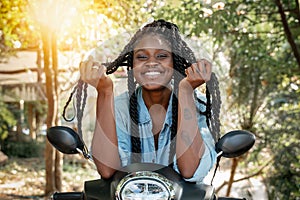 Charming young african american girl woman with a perfect smile and black pigtails sitting on a motobike